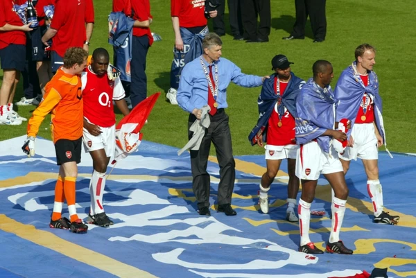 Arsene Wenger the Arsenal Managertalks to Ashley Cole at the end of the match