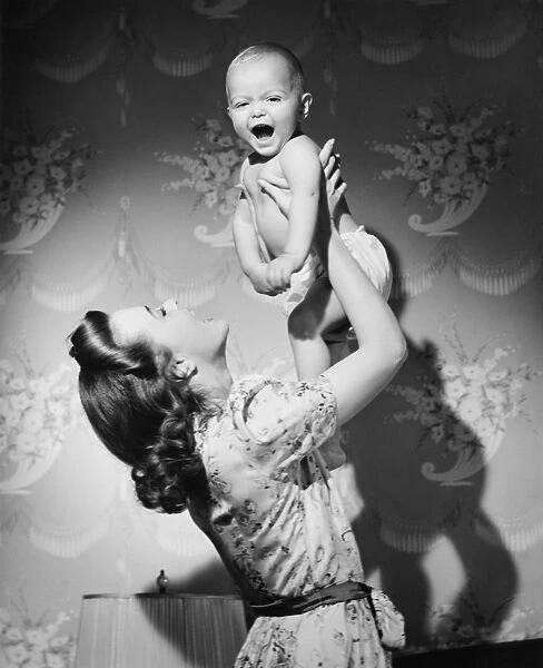 Mother with baby (6-9 months) playing at home, (B&W)