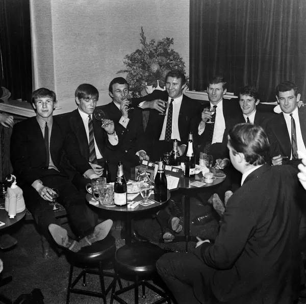 Manchester City players and management staff celebrate with a few drinks