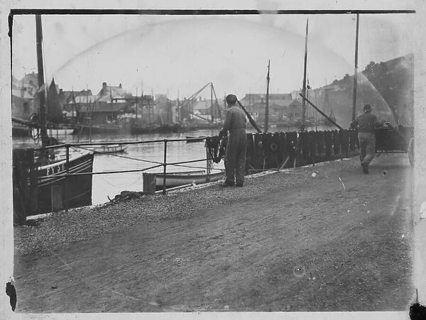 Fisherman hanging out nets on West Looe quay
