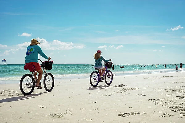 Florida, Sarasota, Siesta Key, Couple Bike riding on beach