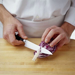 Using kitchen knife to remove hard core from centre of red cabbage slice