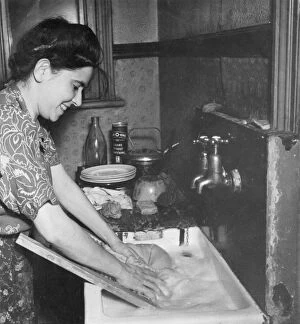 Bottle Collection: Young woman washing clothes at a sink