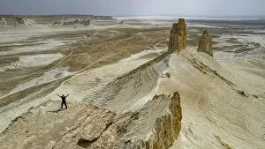 Kazakhstan Pillow Collection: Aerial of a man standing on a cliff, Bozzhira Canyon, Ustyurt plateau, Mangystau, Kazakhstan