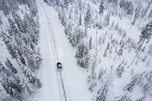 Finland Photo Mug Collection: Aerial shot of a car crossing the boreal forest covered with snow, Akaslompolo, Finnish Lapalnd