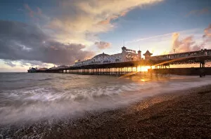 Brighton & Hove Framed Print Collection: Brighton Pier at sunset with dramatic sky and waves washing up the beach, Brighton