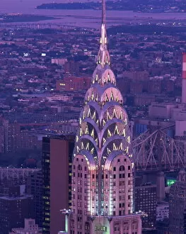Sky Scrapers Collection: The top of the Chrysler Building illuminated in the evening with a bridge