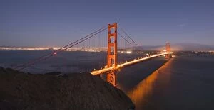 International Landmarks Collection: Golden Gate Bridge glowing at sunset with the San Francisco skyline behind