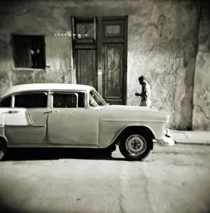 Old Havana and its Fortification System Collection: Image taken with a Holga medium format 120 film toy camera of man walking past old American car
