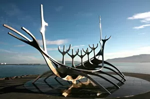 Reykjavik Photographic Print Collection: The midnight sun lights up the giant steel boat sculpture that stands on the waters edge at