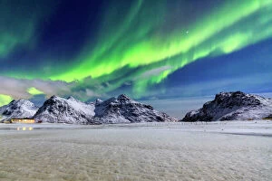 Phenomenon Collection: Northern Lights (aurora borealis) illuminate the sky and the snowy peaks, Flakstad