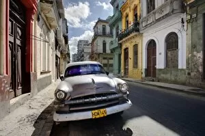 Plymouth Collection: Old American Plymouth car parked on deserted street of old buildings, Havana Centro