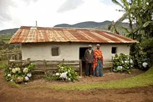 Equator Collection: Burundi. A couple outside a traditional house on their farm