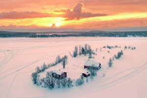 Freeze Collection: Europe, Finland, Rovaniemi, aerial view of a frozen lake near Rovaniemi with traditional red