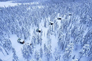 North Collection: Glass cabins set on the middle of the frozen forest covered with snow at dusk, Finnish Lapland