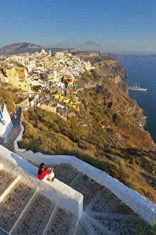 Traditionally Greek Collection: Greece, The Cyclades, Santorini (Thira), Fira, Woman sitting on wall in town (MR)