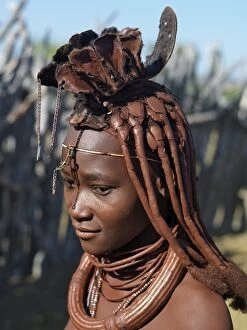 Conch Poster Print Collection: A Himba woman in traditional attire. Her body gleams from a mixture of red ochre