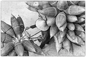 Non La Collection: A man on the bicycle loaded with the conical bamboo fish traps, near Hanoi, Vietnam