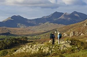 Tourist Collection: North Wales, Snowdonia. A man and woman stop to look at their map whilst hiking in Snowdonia
