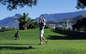 Healthy Lifestyle Collection: A player tees off at the golf course at Green Point overlooked by Table Mountain