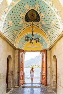 Dodecanese Islands Collection: A woman in a hat at Panormitis Monastery, Symi, Dodecanese Islands, Greece