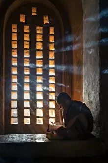 Studying Collection: A young monk studying by a window inside a temple, UNESCO, Bagan, Mandalay Region