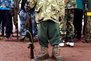 Related Images Jigsaw Puzzle Collection: A former child soldier holds a gun as they participate in a child soldiers release ceremony