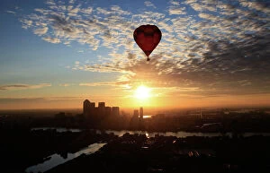 2012 Framed Print Collection: A hot air balloon rises into the early morning sky in front of the Canary Wharf financial