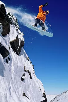 Plunging Collection: Man on a snowboard jumping off a cornice at Snowbird Resort in Little Cottonwood