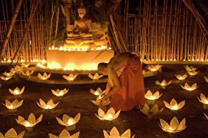 Monk Collection: Monks lighting khom loy candles and lanterns for Loi Krathong festival
