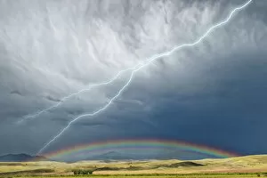 Desert landscapes Poster Print Collection: USA, Montana, Galen. Storm clouds with lightning and rainbow