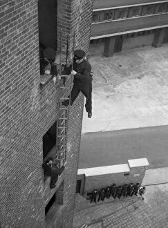 London Fire Brigade Collection: Firefighter during hook ladder practice