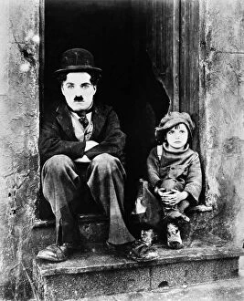 Door Way Collection: CHAPLIN: THE KID, 1921. Charlie Chaplin and Jackie Coogan as his adopted son in Chaplins film The