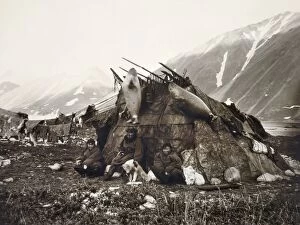 Anthropology Collection: ESKIMO DWELLING, c1899. A group of three Inuits sitting in front of their house