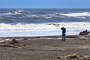 West Coast Pillow Collection: A photographer photographing the waves on the beach at Hokitika in West Coast, New Zealand