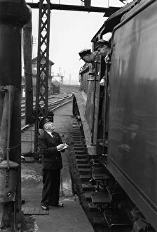 Science Museum Photographic Print Collection: Driver and fireman consulting with station guard, c 1956