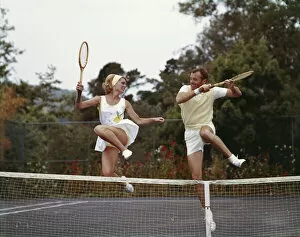 Focus On Foreground Collection: Couple jumping on tennis court, smiling