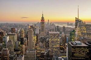 City Street Collection: New York City skyline with illuminated skyscrapers seen from above during sunrise, New York State