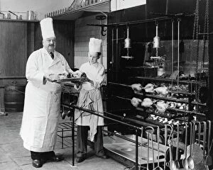 Brighton Collection: A. H. Cadier, senior chef at the Brighton Pavilion is handed fake chickens by junior