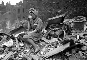 Muridae Framed Print Collection: A woman enjoys a cup of tea in the midst of the bomb damage at New Cross after air raids