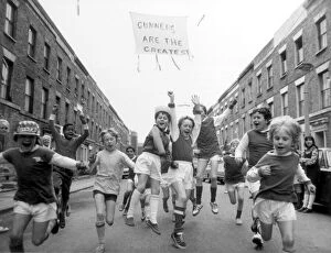 Running Collection: Young Arsenal fans on Blundell street, Islington, cheer for the upcoming victory against